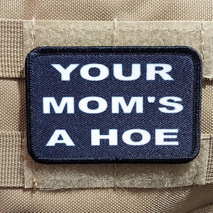 以下が含まれることがあります： 「YOUR MOM'S A HOE」と白文字で書かれた黒いパッチ。