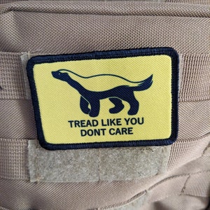 May include: A yellow and black patch with a honey badger illustration and the text "Tread Like You Don't Care".