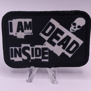 May include: Black and white embroidered patch with the text "I AM DEAD INSIDE" and a skull graphic.