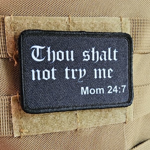 以下が含まれることがあります： 「Thou shalt not try me Mom 24:7」と白文字で書かれた黒いパッチ。