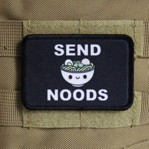 May include: A black and white patch with the text "SEND NOODS" and a cartoon image of a bowl of noodles with a smiling face.