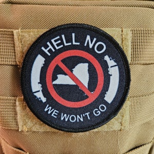 May include: A black and white patch with a red circle and a white outline. The circle has a diagonal line through it and a white silhouette of a state inside. The text "HELL NO WE WON'T GO" is around the circle.