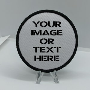 Puede incluir: Un parche redondo blanco con un borde negro. El parche tiene el texto "YOUR IMAGE OR TEXT HERE" impreso en él.