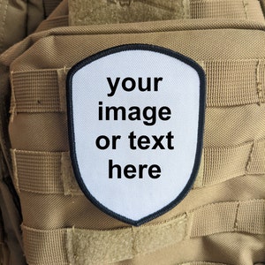 Könnte beinhalten: Ein brauner taktischer Rucksack mit einem weißen Patch, auf dem "your image or text here" steht.