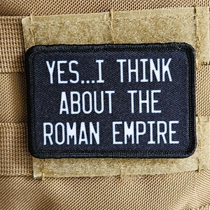 Può includere: Una toppa nera con testo bianco che recita "YES...I THINK ABOUT THE ROMAN EMPIRE".