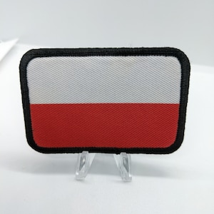 May include: A white and red embroidered patch with a black border, depicting the flag of Poland.