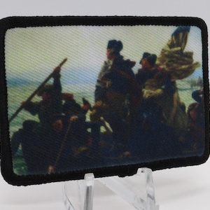 May include: Rectangular patch featuring a historical painting of a boat with several figures, likely a depiction of a famous event. The patch has a black border and a fabric-like texture. The image is a colorful representation of the scene.