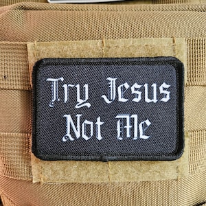 May include: A black patch with white text that reads "Try Jesus Not Me" on a tan background.