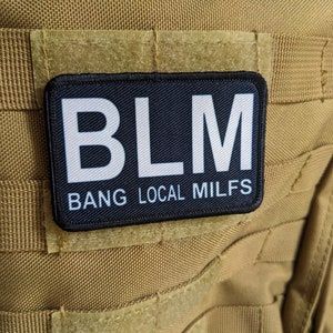 May include: Black patch with white text that reads "BLM BANG LOCAL MILFS" on a tan background.