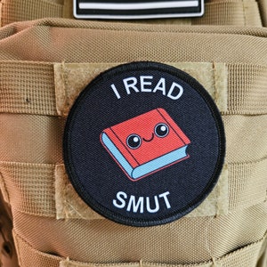 Parche moral extraíble con forma de círculo de 3" y con velcro en la parte posterior que dice "Leo libros picantes y obscenos"