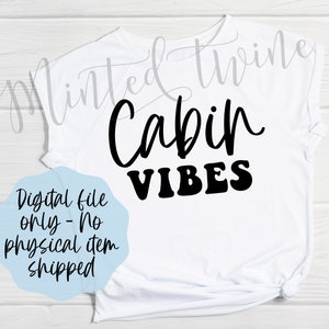 May include: White t-shirt with black text that reads "Cabin Vibes".