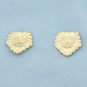 May include: Two gold-toned metal bead caps shaped like stylised flower petals. Each piece features a scalloped edge and a central circular hole, designed with radiating embossed lines that extend from the centre to the outer perimeter.