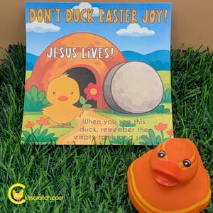 May include: A colorful Easter-themed card with the text "DON'T DUCK EASTER JOY! JESUS LIVES!". The card features a cartoon chick, an empty tomb, and a large egg. An orange rubber duck is in the foreground.