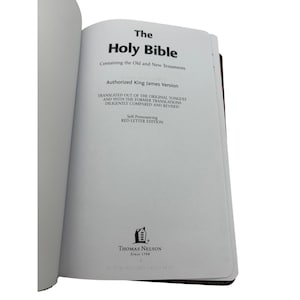 Puede incluir: Libro abierto titulado "The Holy Bible" con el texto "Authorized King James Version" y "Self-Pronouncing RED-LETTER EDITION". Las páginas del libro son blancas y la portada es marrón. El logotipo del editor, "THOMAS NELSON Since 1798", es visible.