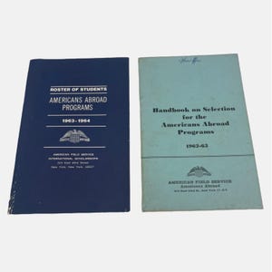 May include: Two blue and light blue paperbacks titled "Roster of Students Americans Abroad Programs 1963-1964" and "Handbook on Selection for the Americans Abroad Programs 1962-63". Both books feature the American Field Service International Scholarships logo.