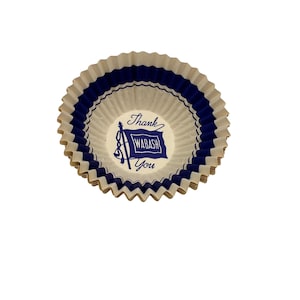 May include: A stack of white and blue paper cupcake liners. The liners have a scalloped edge and a blue band around the top. The center of the liner has the words "Thank Wabash You" in blue.