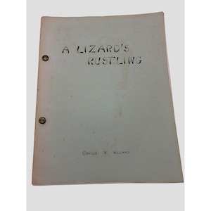 May include: A light-colored document bound with two metal fasteners on the left side. The title A LIZARD'S RUSTLING is printed in black ink near the top, and the name ORVILLE N. WILLIAMS is printed in black ink near the bottom of the cover.