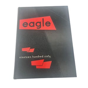 May include: A black book with the word "eagle" in a red rectangle at the top. Below, the text "nineteen hundred sixty" is printed in white. Red geometric shapes are also present.