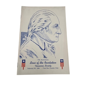 Op de afbeelding: Een vintage programmacover met een blauwe lijntekening van een mannenprofiel. De tekst luidt "70th Anniversary Sons of the Revolution Tennessee Society February 22, 1964: C'est Bon Country Club."