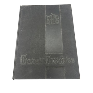 Puede incluir: Un anuario de tapa dura negra con el texto en relieve "EHS" y "Golden Fleece '68". La cubierta es de color negro liso con un elemento de diseño rectangular en el centro.