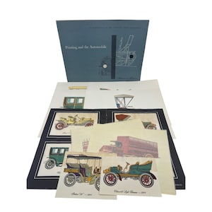 May include: An exhibition catalog titled "Printing and the Automobile" with illustrations of vintage cars. The catalog is blue with white text and a diagram. Several prints of antique cars are displayed, showcasing various models and designs.