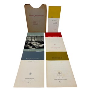 May include: A collection of vintage educational materials, including booklets and a folder. The folder is tan with the text "Tests and Measurement Kit." Booklets have titles like "Evaluation and Advisory Service" and "Making the Classroom Test." The color palette includes tan, yellow, blue, and red.