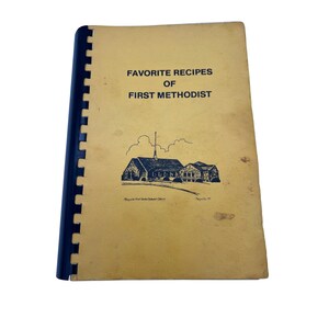 Könnte beinhalten: Ein Vintage-Kochbuch mit dem Titel "Favorite Recipes of First Methodist" mit Spiralbindung. Das Cover ist vergilbt mit schwarzem Text und einer Kirchenillustration. Das Kochbuch stammt aus Maryville, TN.