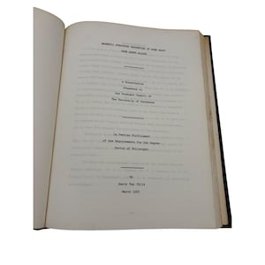 May include: An open book with text on the pages. The text includes the title "MAGNETIC STRUCTURE PROPERTIES OF SOME HEAVY RARE EARTH ALLOYS", and the text "A Dissertation Presented to the Graduate Council of The University of Tennessee".