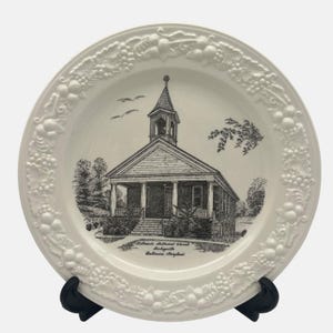 May include: White ceramic plate with a black and white image of the Ridgely Methodist Church in Ridgely, Baltimore, Maryland. The plate has a raised border with a grapevine design.