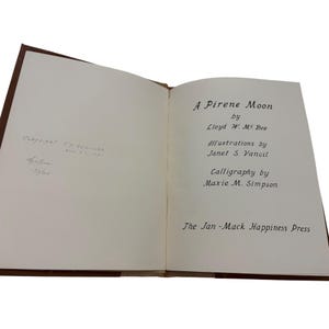 May include: An open book titled "A Pirene Moon" by Lloyd W. Mc Bee. The book features illustrations by Janet S. Vancil and calligraphy by Maxie M. Simpson. Published by The Jan-Mack Happiness Press.
