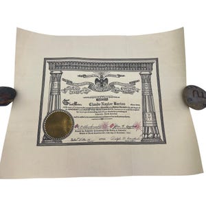 May include: A vintage certificate with an elaborate black and white border, featuring columns and a seal. The document displays the name "Claude Naylor Burton" and text related to the Ancient Accepted Scottish Rite. The paper has a slightly aged appearance.