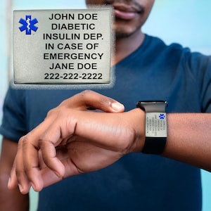 May include: A medical alert bracelet and a medical ID tag. The bracelet is black with white text and a blue medical symbol. The tag is gray with black text and a blue medical symbol. The text on the tag reads: JOHN DOE, DIABETIC, INSULIN DEP., IN CASE OF EMERGENCY, JANE DOE, 222-222-2222.