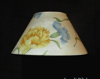 lampshade in Pierre Frey print fabric with yellow and blue eyelets on a white background