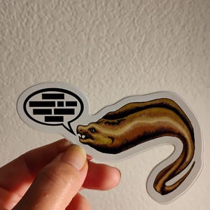May include: A brown and yellow moray eel sticker with a speech bubble that says "brick".
