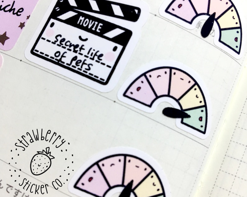 May include: A set of colorful stickers featuring a movie clapperboard with the text "Secret Life of Pets" and a rainbow-colored gauge with a black needle.