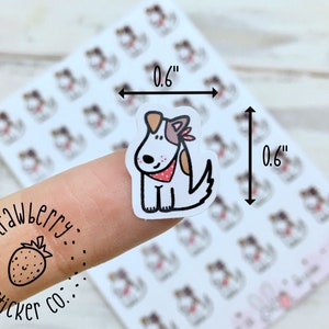 May include: A sheet of 1.5 cm by 1.5 cm stickers featuring a cartoon dog wearing a red bandana. The stickers are printed on white paper and have a glossy finish. The sheet is labelled "Strawberry Sticker Co."