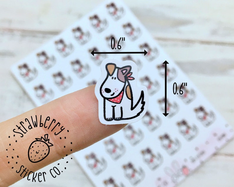 May include: A sheet of 1.5 cm by 1.5 cm stickers featuring a cartoon dog wearing a red bandana. The stickers are printed on white paper and have a glossy finish. The sheet is labelled "Strawberry Sticker Co."