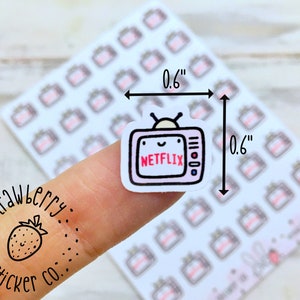 Puede incluir: Una hoja de pegatinas de 1,5 cm por 1,5 cm con un televisor de dibujos animados con una cara sonriente y la palabra "NETFLIX" en la pantalla. Las pegatinas est&aacute;n sobre un fondo blanco.
