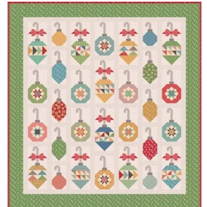 May include: A Christmas-themed quilt featuring a grid of colorful, geometric ornament designs. Each ornament has a silver hook and a red bow. The ornaments are in various colors, including blue, green, yellow, and red, with geometric patterns. The quilt has a green border.