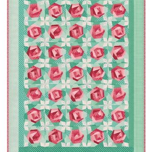 May include: A handmade quilt featuring a repeating pattern of pink rose-shaped blocks on a light green background. The quilt has a border of varying green patterns and a pink trim. The design is symmetrical and visually appealing.