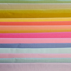 May include: A stack of fabric swatches in various pastel colors, including green, yellow, orange, pink, blue, and purple.