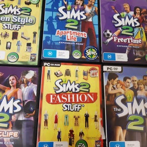 Puede incluir: Seis cajas de juegos para PC de Los Sims 2, incluyendo Teen Style Stuff, Apartment Life y FreeTime. Las cajas presentan gráficos coloridos de personajes y elementos relacionados con el juego. Los juegos están clasificados M para Mature.