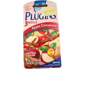 May include: A PlugIns air freshener refill pack with an Apple Cinnamon scent. The packaging shows apples and cinnamon sticks. The pack contains 3 refills and has a "Scratch & Sniff" sticker. Each refill weighs 4.8g, with a total net weight of 14.4g.