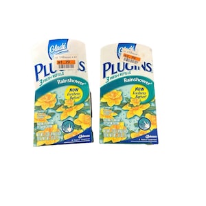 May include: Two Glade PlugIns air freshener refills, Rainshower scent. Each pack has a white background with blue and yellow floral graphics. Text includes "3 Fresh Refills" and "Now Freshens Better!"