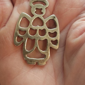 Puede incluir: Colgante de &aacute;ngel plateado con halo y alas caladas. El colgante est&aacute; suspendido de un peque&ntilde;o lazo, adecuado para un collar o pulsera de abalorios. El dise&ntilde;o del &aacute;ngel es sencillo y elegante, perfecto para joyer&iacute;a religiosa o espiritual.