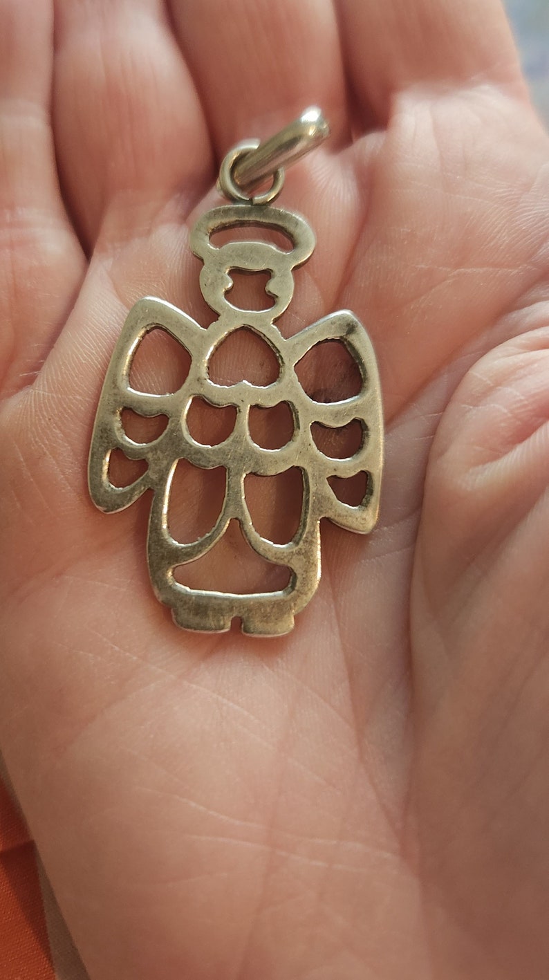 Puede incluir: Colgante de &aacute;ngel plateado con halo y alas caladas. El colgante est&aacute; suspendido de un peque&ntilde;o lazo, adecuado para un collar o pulsera de abalorios. El dise&ntilde;o del &aacute;ngel es sencillo y elegante, perfecto para joyer&iacute;a religiosa o espiritual.