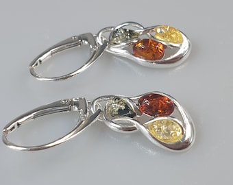May include: Silver earrings with a dangling design featuring three amber stones in shades of green, orange, and yellow.