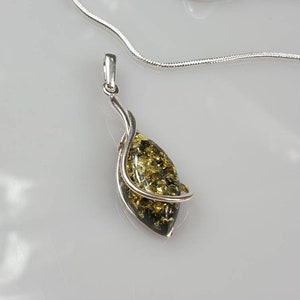 May include: A silver chain necklace with a pendant featuring a green and gold amber stone wrapped in silver.