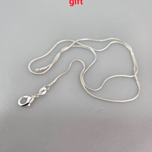 May include: A silver plated chain necklace with a lobster clasp closure.