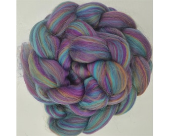 Könnte beinhalten: Ein Bündel bunter Wollrohlinge in den Farben Lila, Türkis und Braun. Die Wolle ist in einem geflochtenen Muster angeordnet.